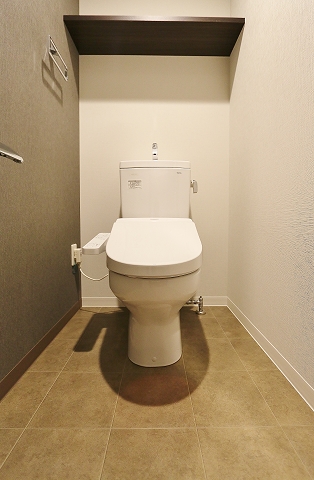 収納棚付きの清潔感あるトイレです