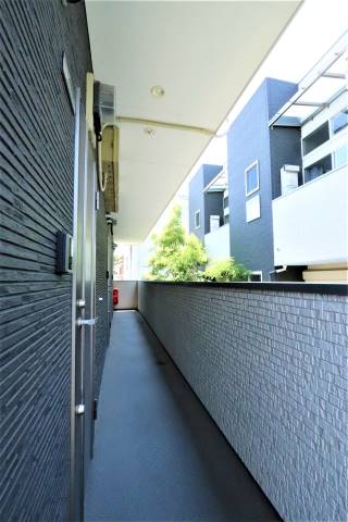 通路から緑が見えて、温かい雰囲気のアパートです